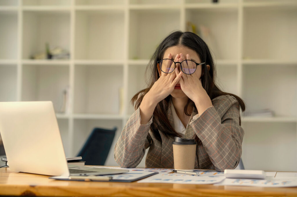 Stressed person overwhelmed by perfectionism and obsessive thoughts, illustrating the difference between OCD and perfectionist behavior.